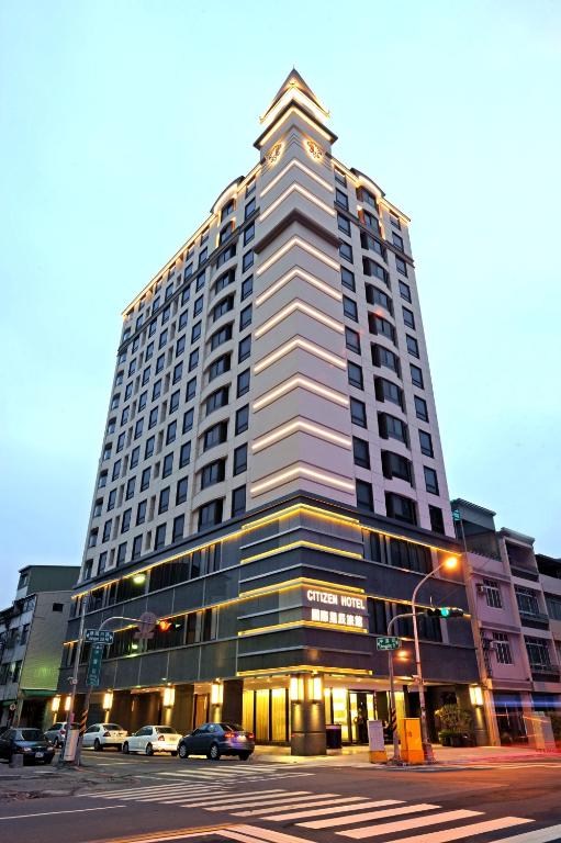 a tall building with cars parked in front of it at International Citizen Hotel in Kaohsiung