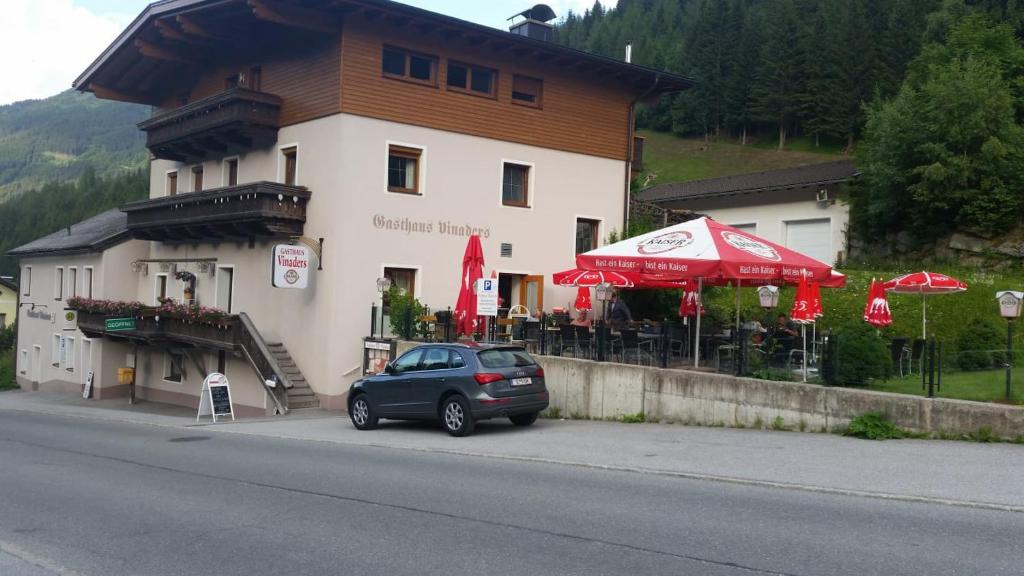 une petite voiture garée devant un bâtiment dans l'établissement Gasthaus Vinaders, à Gries am Brenner