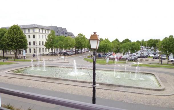 a fountain in the middle of a street with a street light at Les Fontaines Saint Leonard in Honfleur