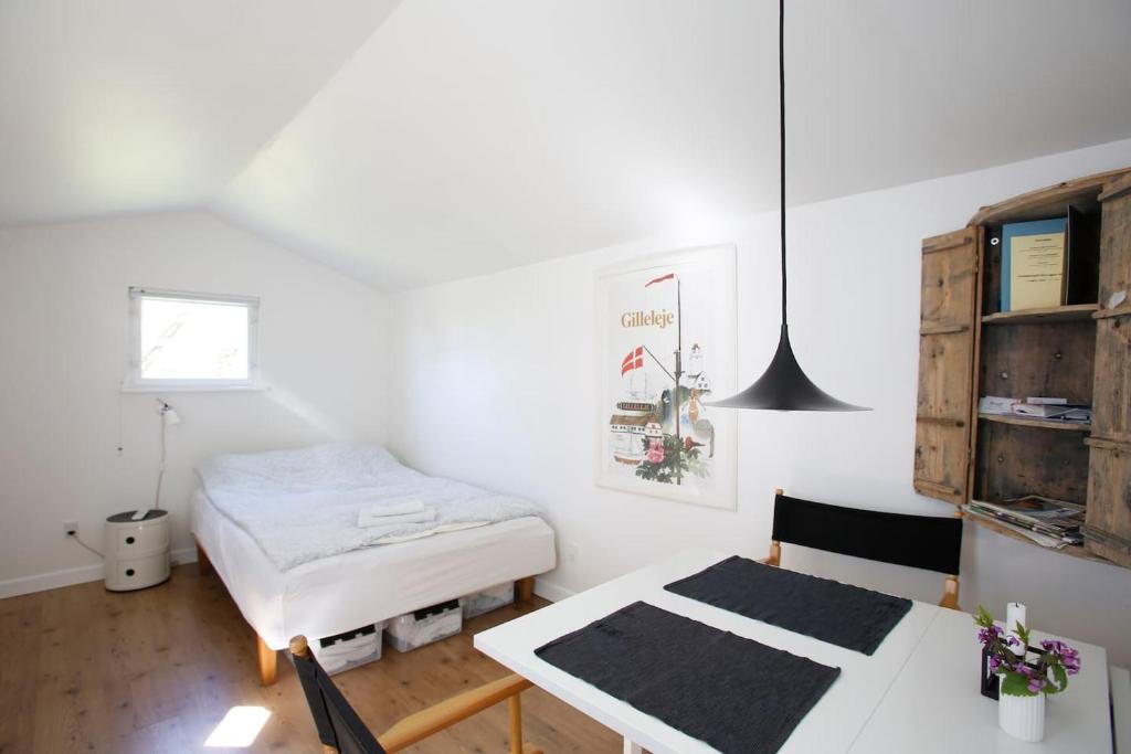1 dormitorio con 1 cama, 1 mesa y 1 silla en Cozy Guesthouse en Gilleleje