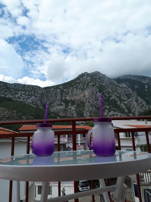 two purple mugs sitting on a table on a balcony at Apartments Vitic in Sutomore