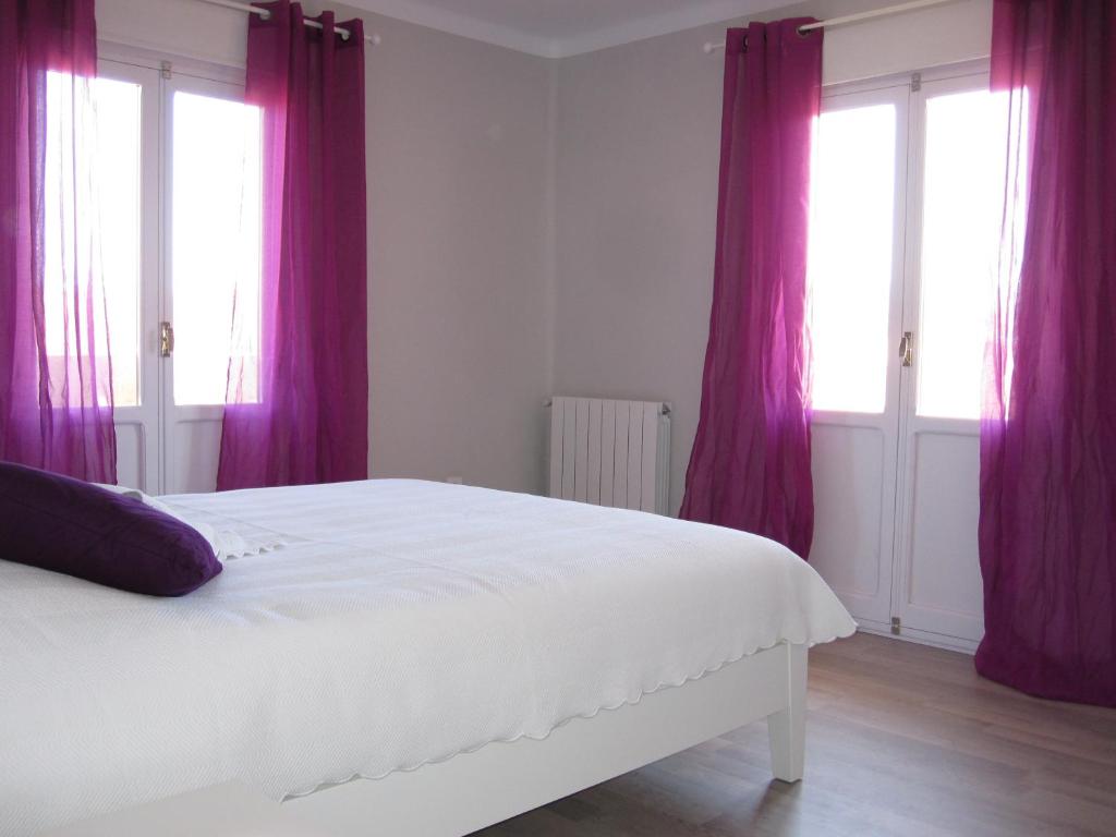 a bedroom with purple curtains and a white bed at Piso centrico amplio-luminoso in Zarautz