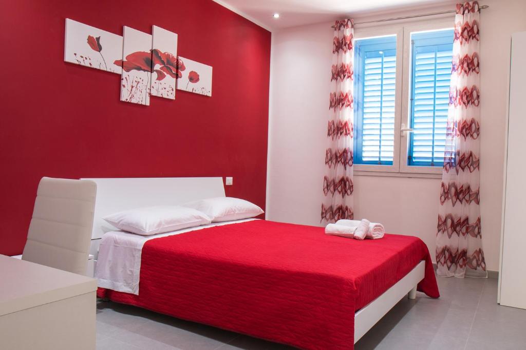 una camera rossa con letto e parete rossa di L'isola del sole a Castelluzzo