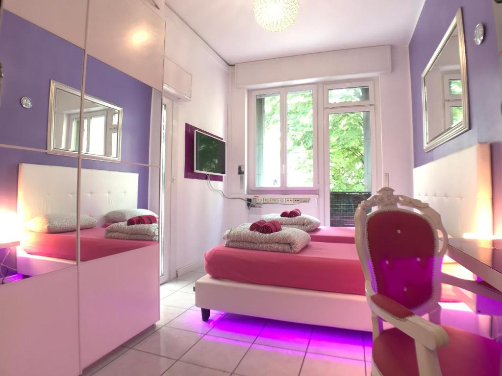 una camera da letto con pareti viola e un letto con una sedia di Duomo Luxury House 9 Pax a Milano