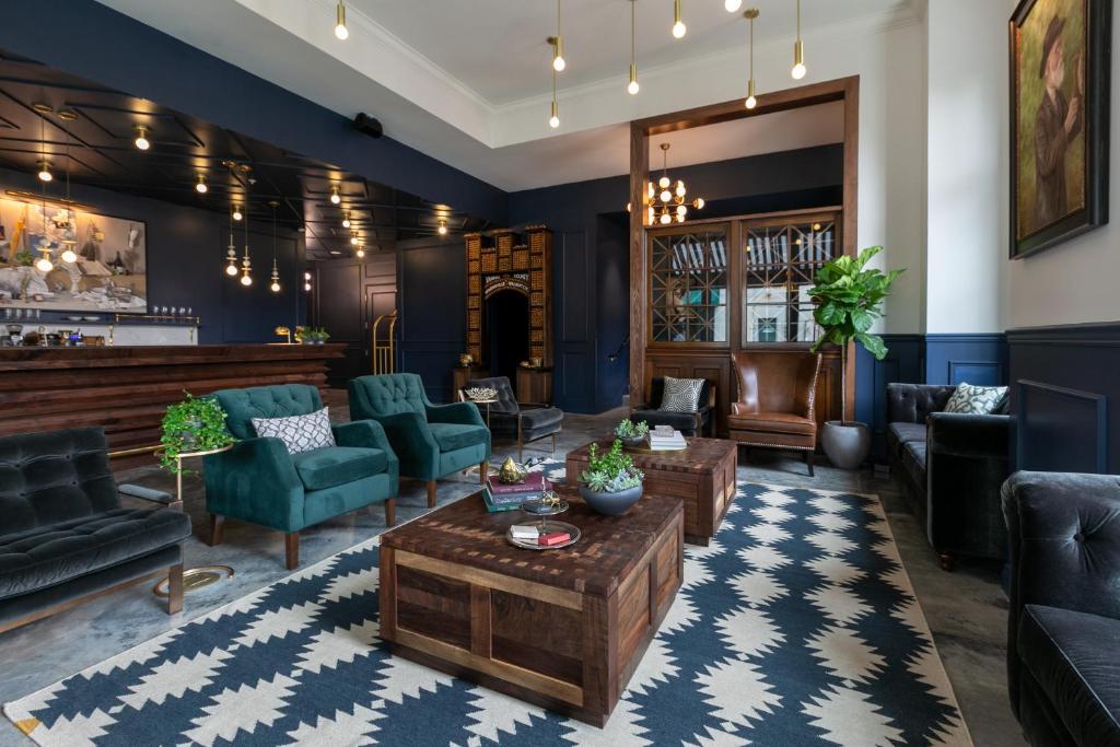 a living room with blue walls and furniture at Atticus Hotel in McMinnville