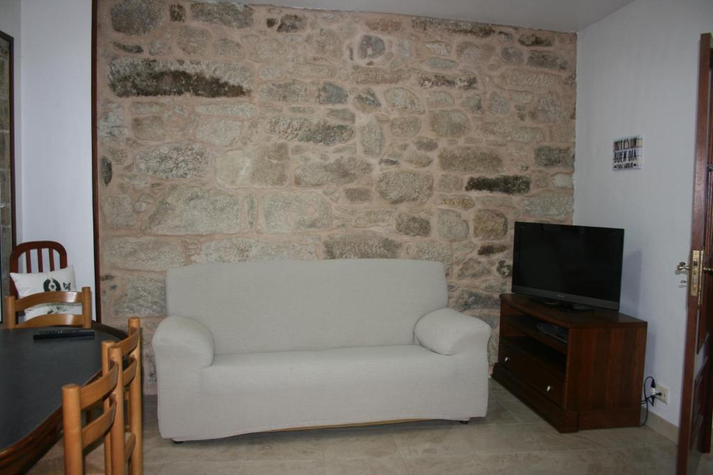 sala de estar con silla blanca y TV en Casa Xa Abreu VUT-CO-002490, en Padrón