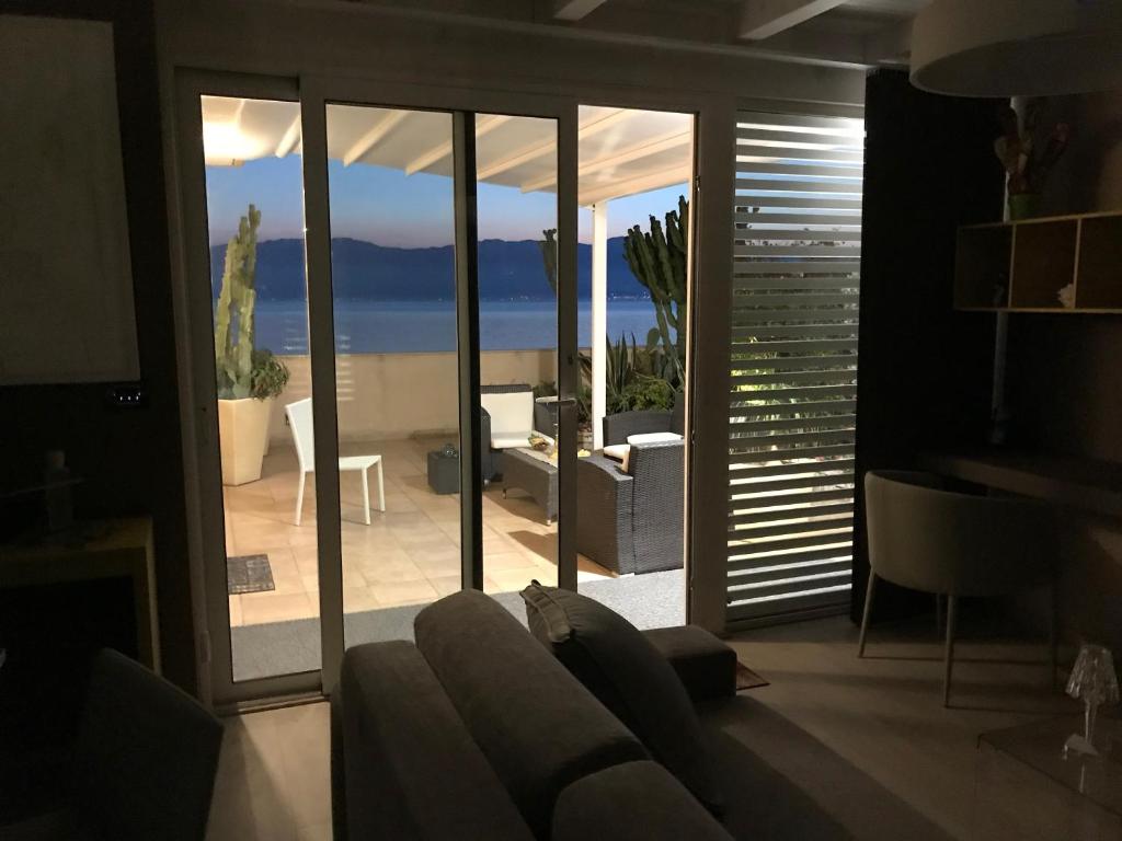 a living room with a couch and a view of the ocean at Sunset Terrazza in Reggio di Calabria