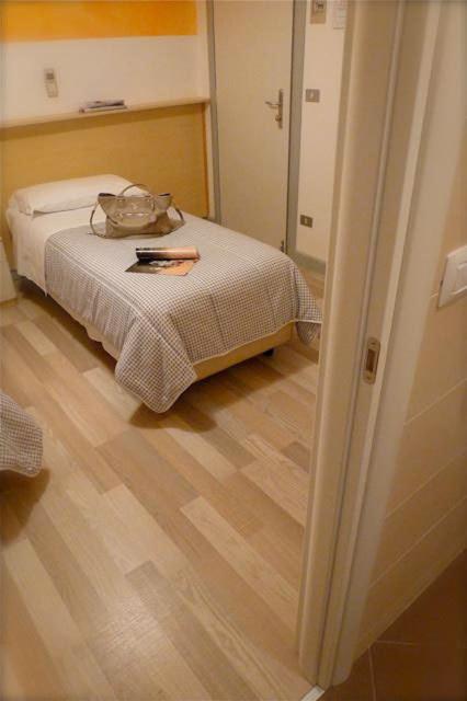 A bed or beds in a room at Hotel Mirella e Ristorante Bar Don Bacco
