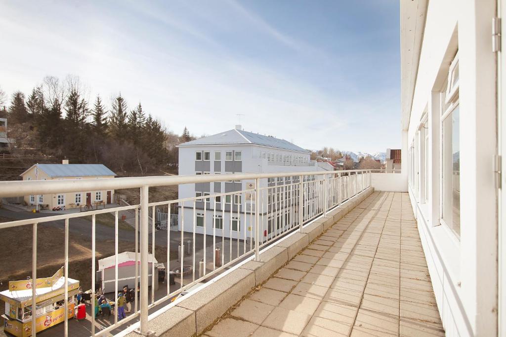 un balcón con una barandilla blanca en un edificio en Apótek Guesthouse, en Akureyri