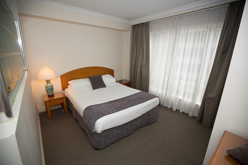 um quarto de hotel com uma cama e uma janela em Bond 215 Self-Catering em Sidney