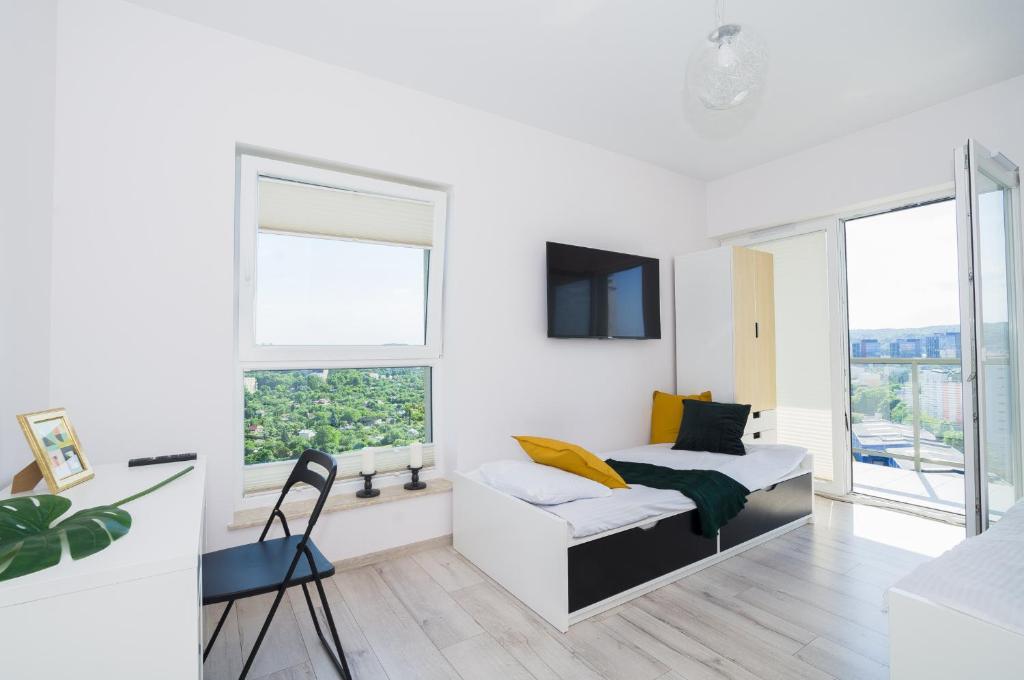 Habitación blanca con cama y silla en Feel Summer Vibes At 3BR Panoramic View Apartment en Gdansk