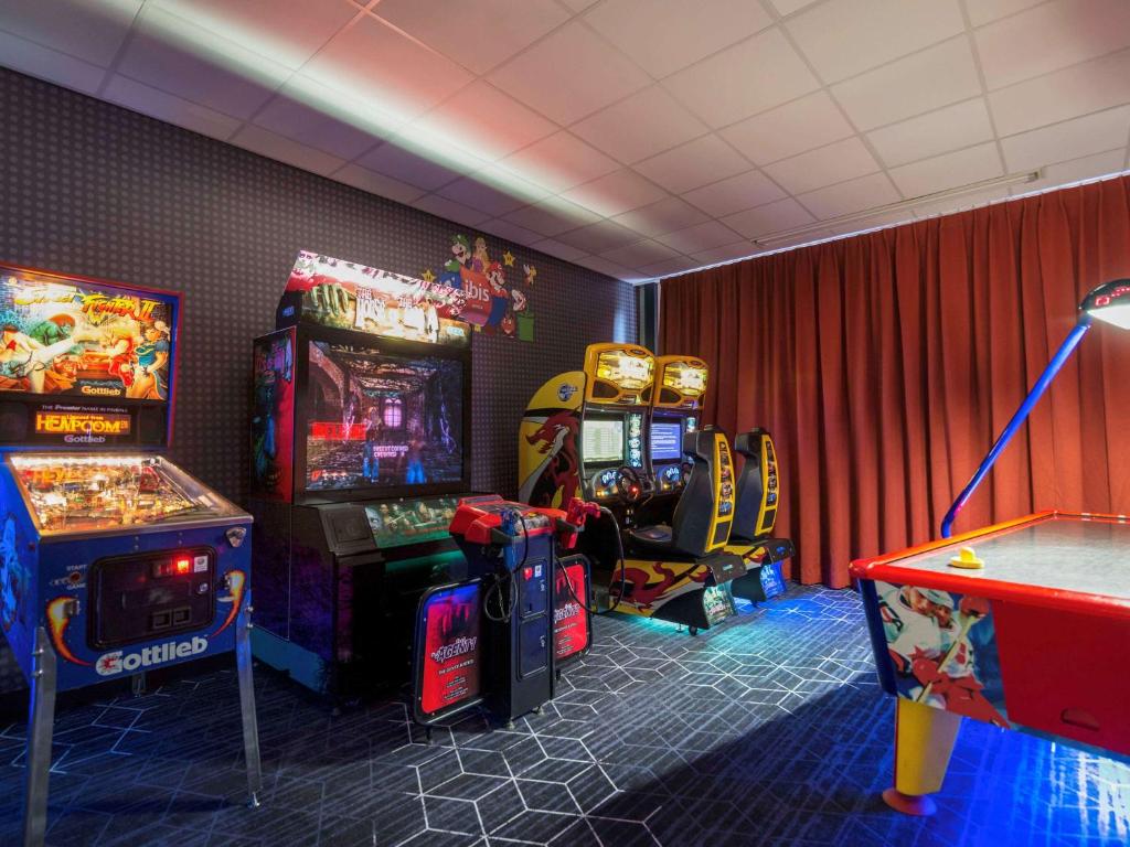 a room with two arcade games and a table at ibis Rotterdam Vlaardingen in Vlaardingen
