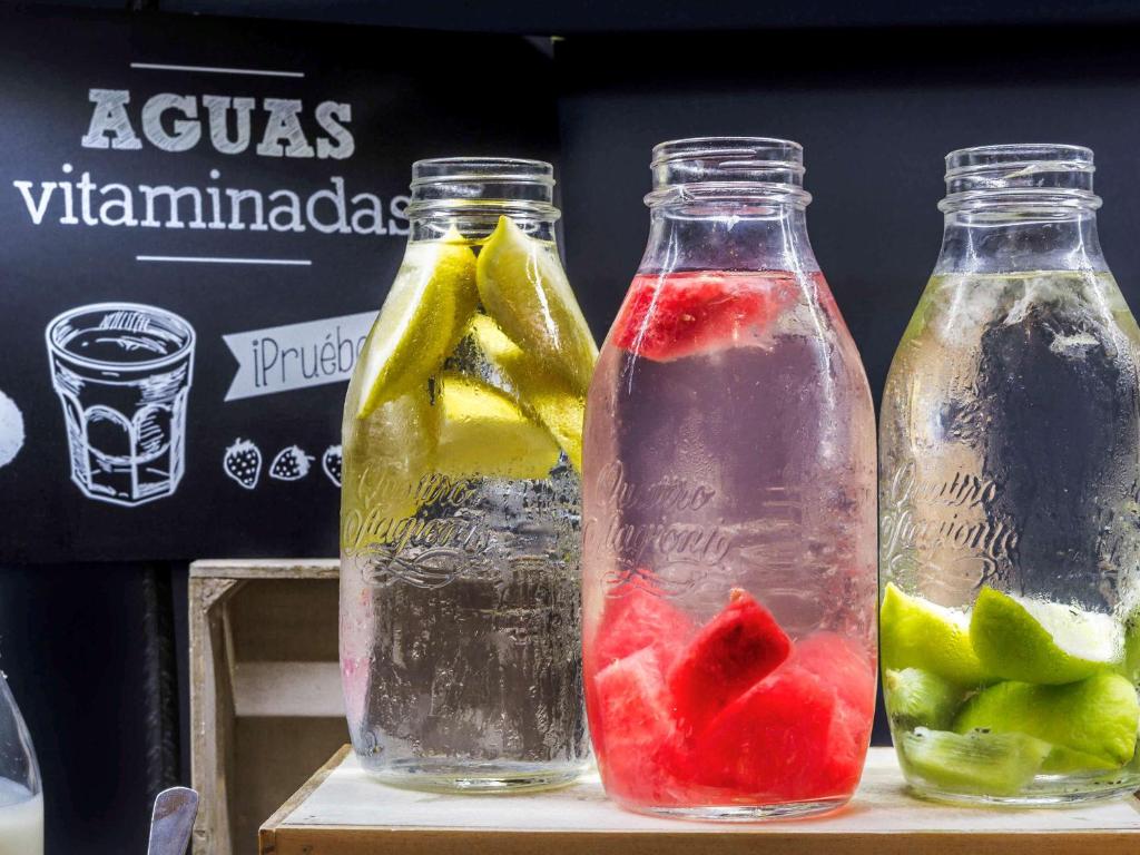 two bottles filled with water and fruit on a table at ibis Birmingham Centre New Street Station Hotel in Birmingham