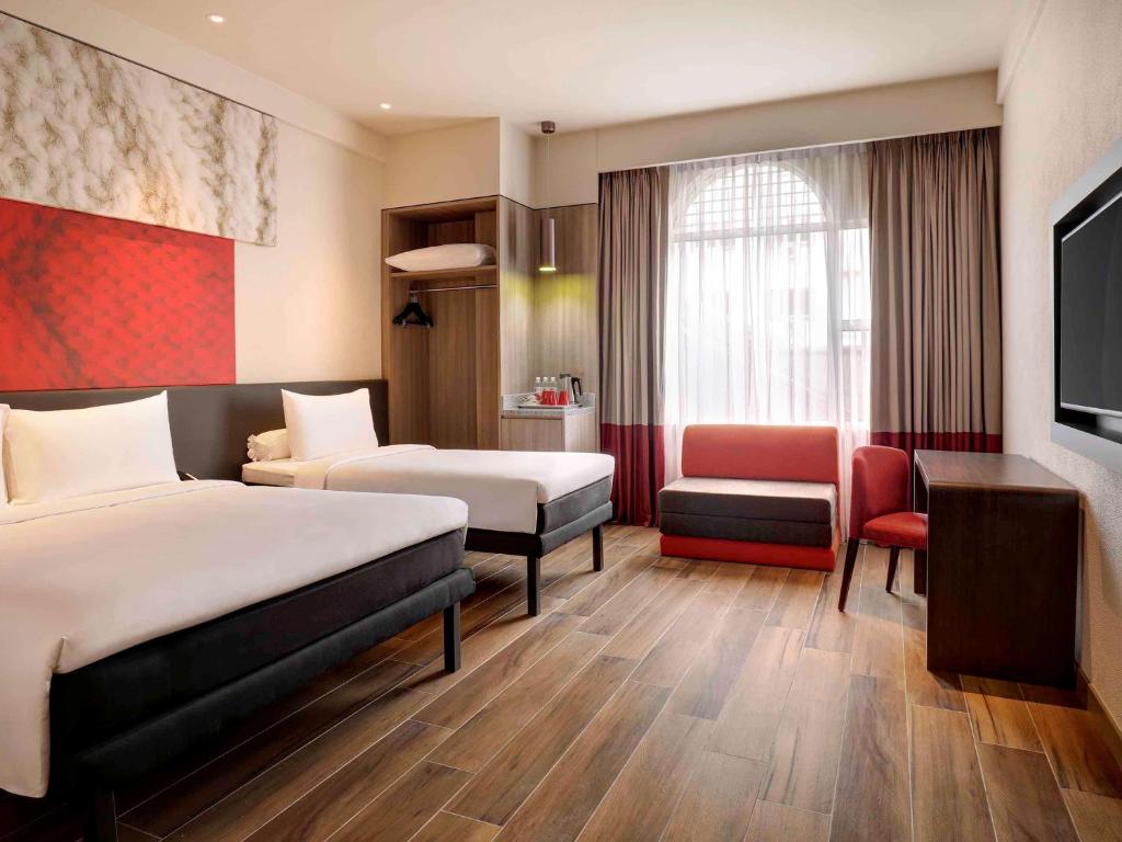 Uma cama ou camas num quarto em Ibis Melaka