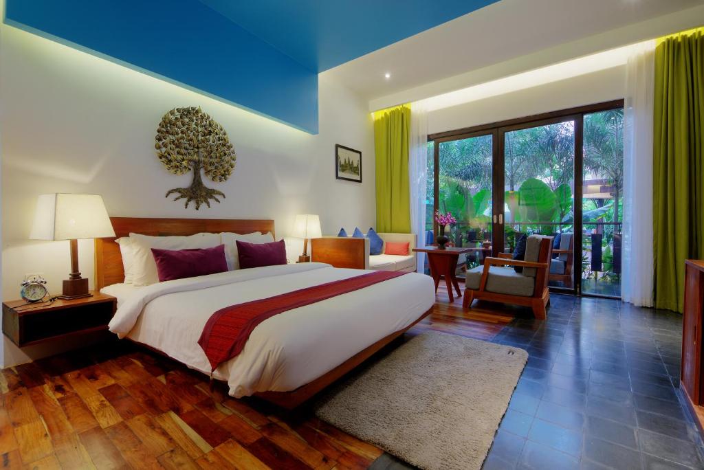 1 dormitorio con cama grande y ventana grande en King Rock Boutique Hotel, en Siem Reap