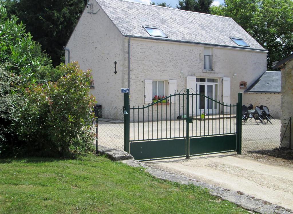 una puerta verde frente a una casa blanca en La grange de Ninon en La Chapelle-Saint-Martin-en-Plaine