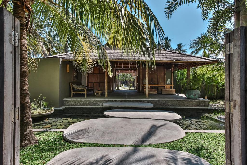 a villa with a resort with a palm tree at Slow Gili Air in Gili Islands