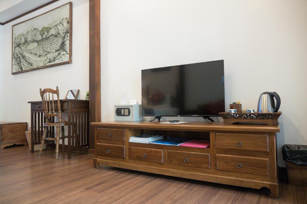 A wooden media console with a flat-screen television and in-room tea facilities.