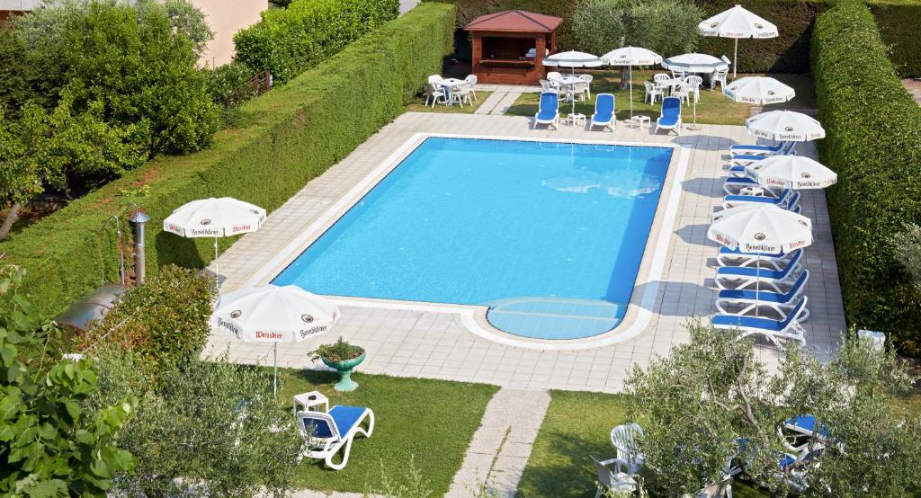 una vista sul soffitto di una piscina con sedie e ombrelloni di Hotel Andreis a Cavaion Veronese