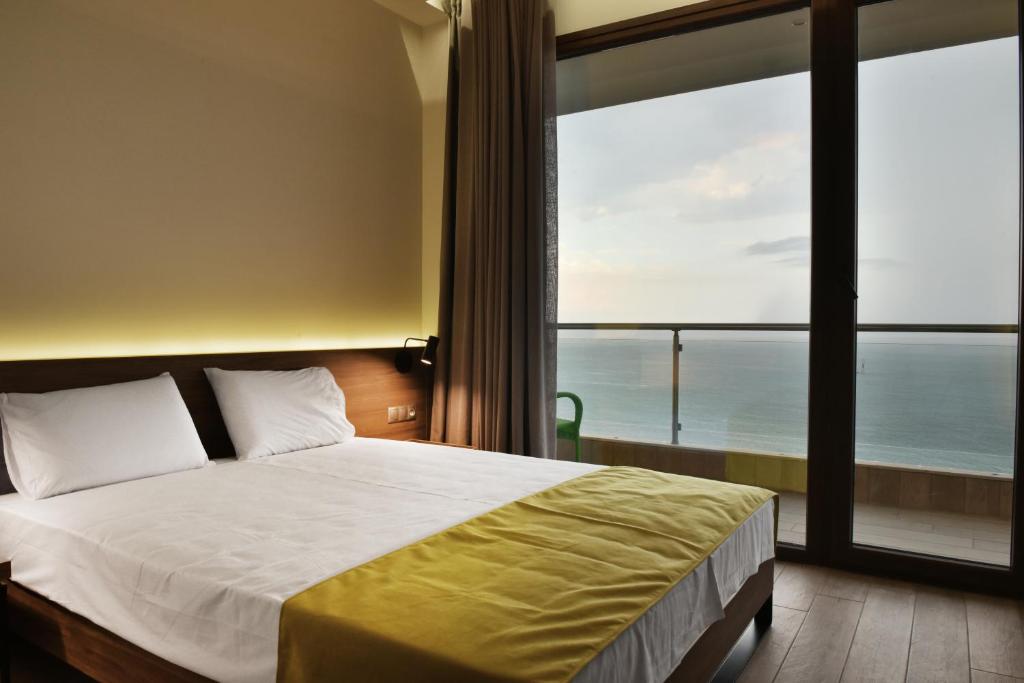 a bedroom with a bed with a view of the ocean at Mistral Hotel in Paralia Katerinis