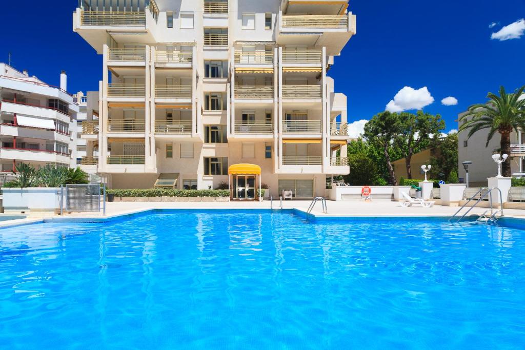 a large swimming pool in front of a building at UHC Novelty Apartments in Salou