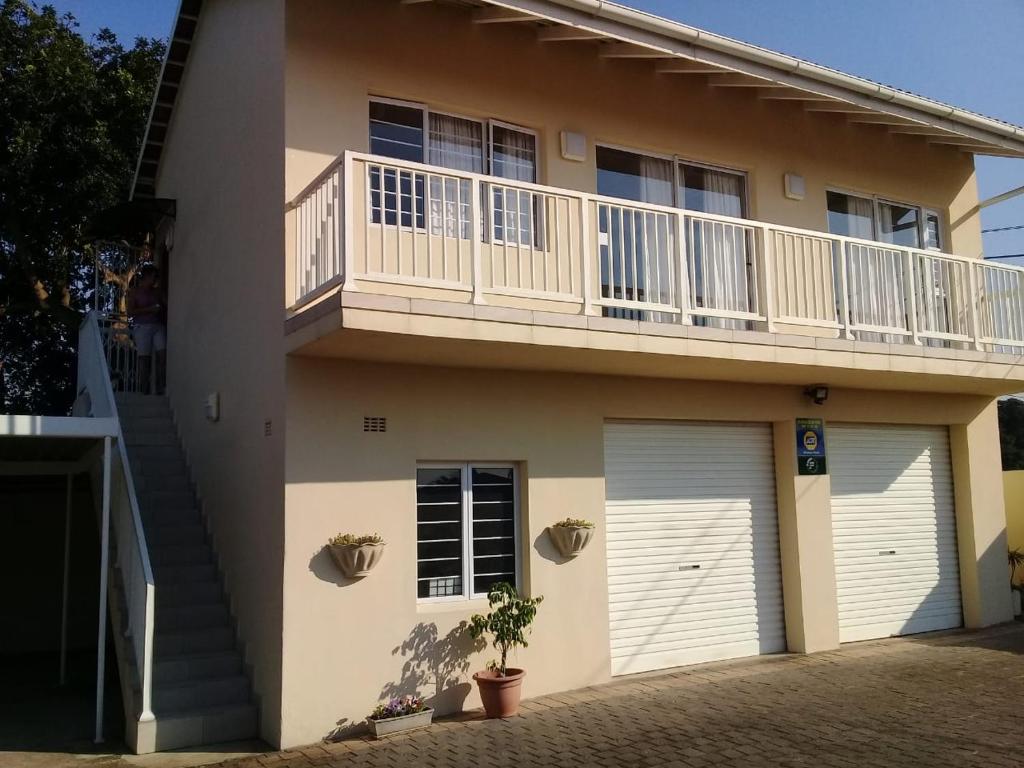 a house with a balcony and two garage doors at Broadway Bay Accommodation in Durban