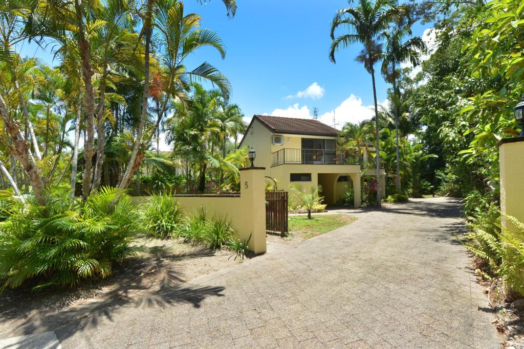 a house with palm trees and a driveway at Sea La Villa Port Douglas in Port Douglas