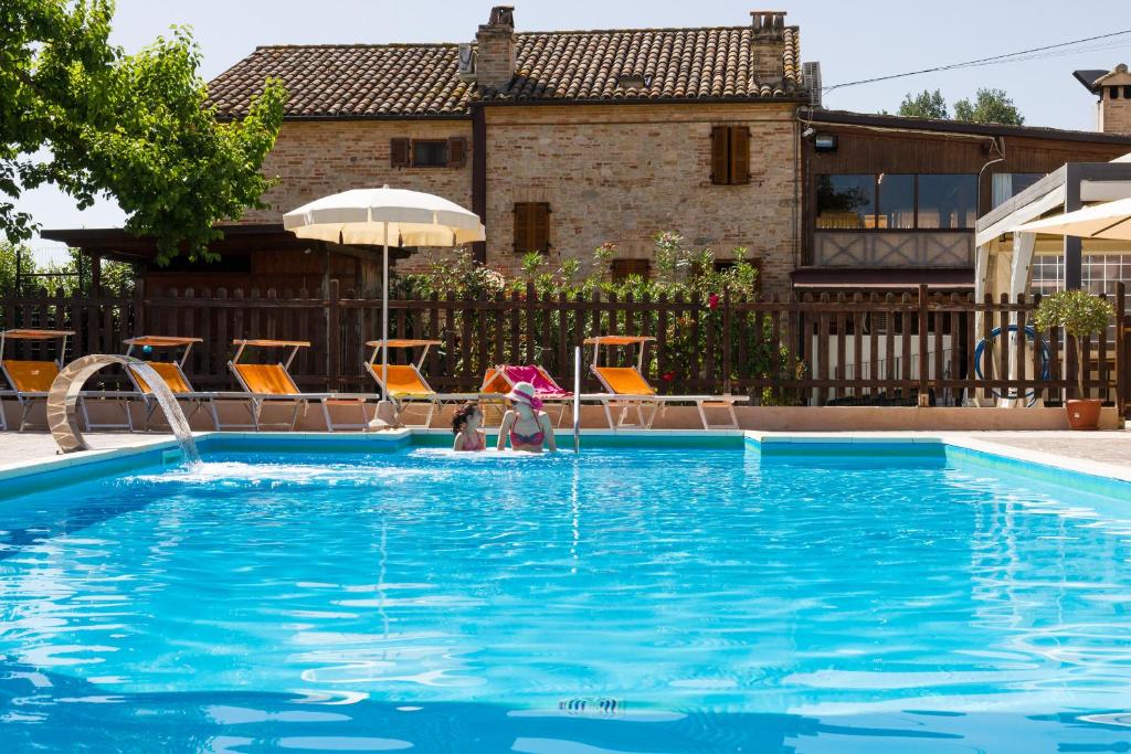 2 personnes jouant dans une piscine dans l'établissement Agriturismo Vecchio Gelso, à Ortezzano