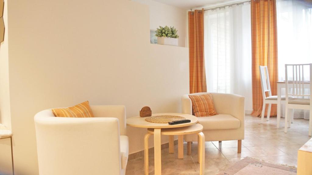 a living room with a table and two chairs at Apartamentai Druskininkuose in Druskininkai