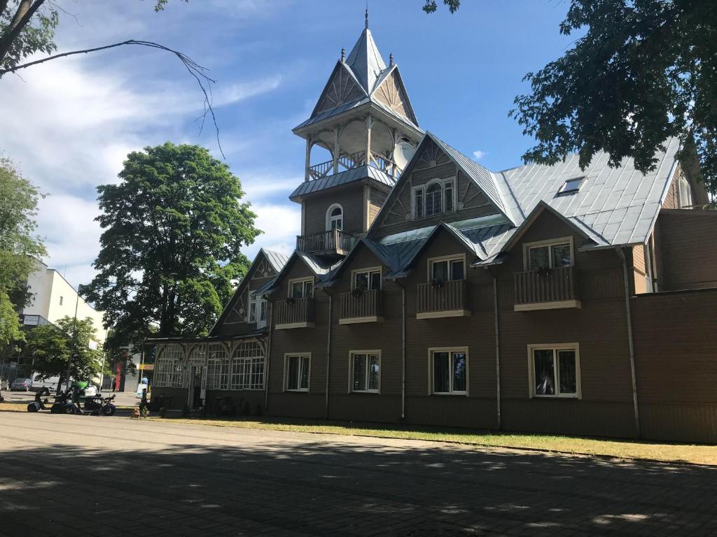 a building with a clock tower on top of it at Druspolis in Druskininkai