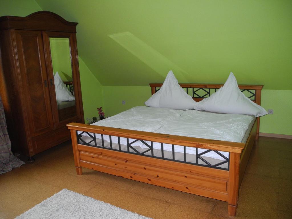 1 cama con almohadas blancas y espejo en una habitación en Ferienwohnung Meyenburg en Schwanewede