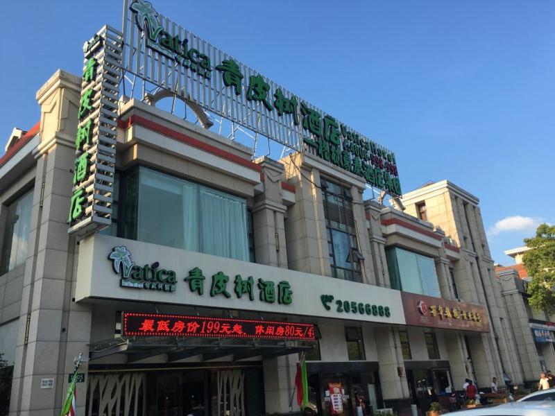 un edificio con letreros en la parte delantera en Vatica ShangHai International Tourism Resort Luoshan Road Subway Station Hotel, en Shanghái
