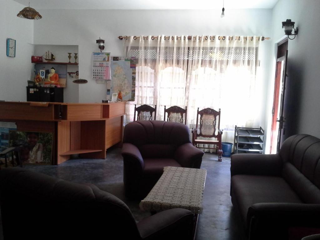 a living room with a couch and chairs and a window at Prasad Suomi Villa in Matara