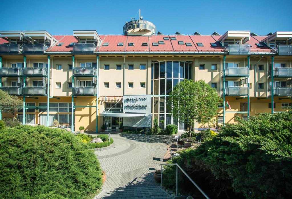a large building with a walkway in front of it at Hotel Panoráma in Balatongyörök