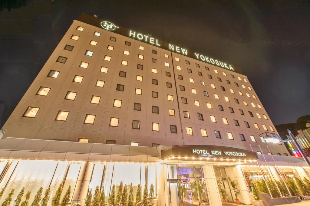 un hôtel neuf vancouver la nuit avec un panneau sur lui dans l'établissement Hotel New Yokosuka, à Yokosuka