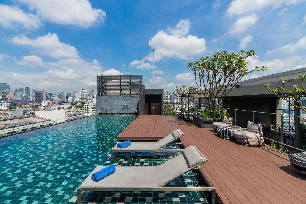 曼谷的住宿－通羅城市住宅飯店，一座带躺椅的屋顶游泳池