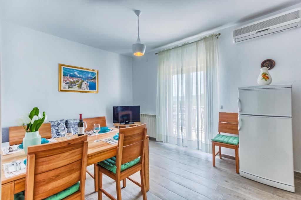カシュテラにあるApartments & Bungalows Ivanovićのキッチン、ダイニングルーム(テーブル、冷蔵庫付)