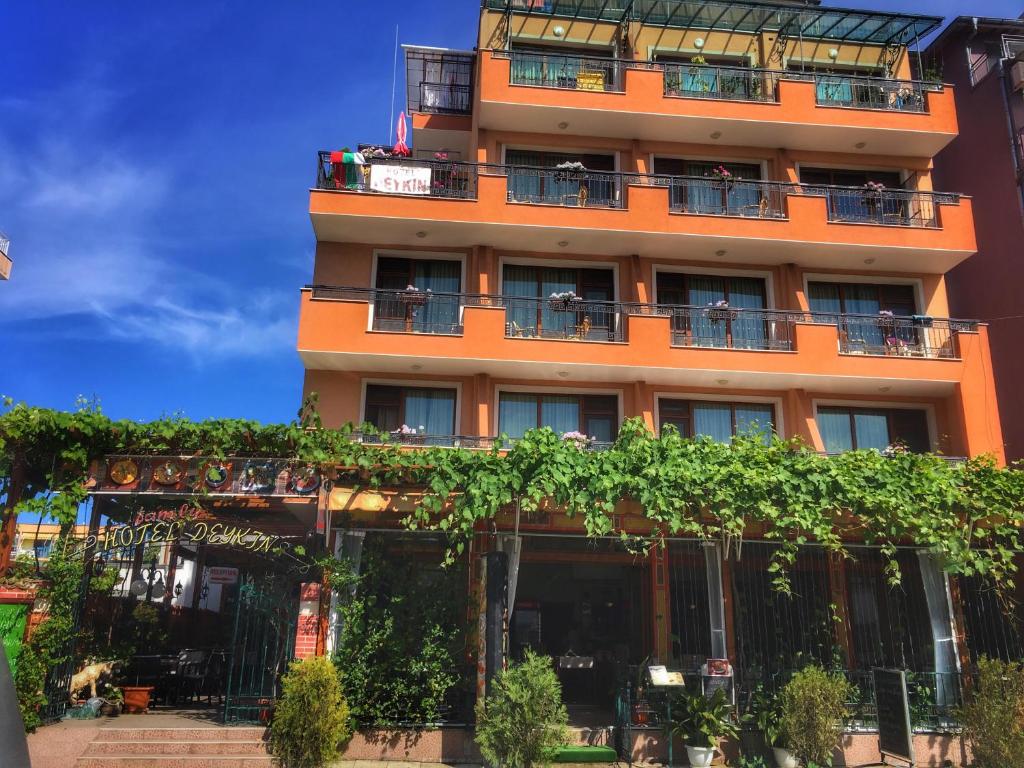 an orange building with people sitting on the balconies at Family hotel Deykin in Sunny Beach