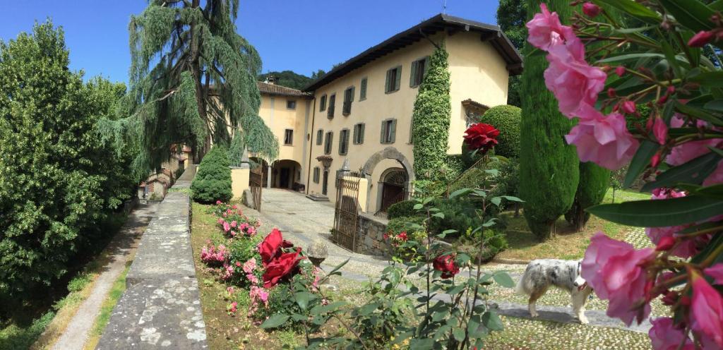 a house with a dog standing in front of a garden at La Volpera in Mapello