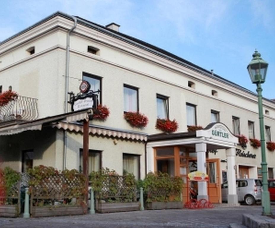 ein weißes Gebäude mit Straßenbeleuchtung davor in der Unterkunft Gasthof Zur Linde in Neuhofen an der Ybbs