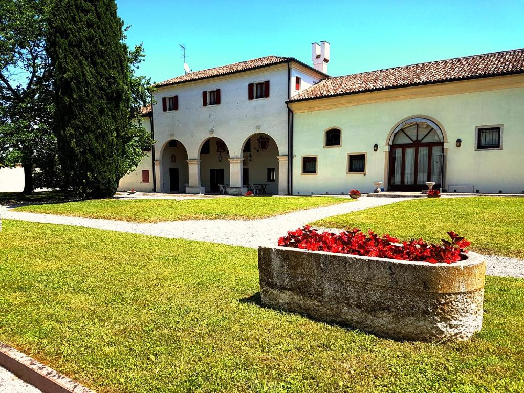 budynek z grupą czerwonych kwiatów na podwórku w obiekcie Alla Barchessa di Villa Querini w mieście Preganziol