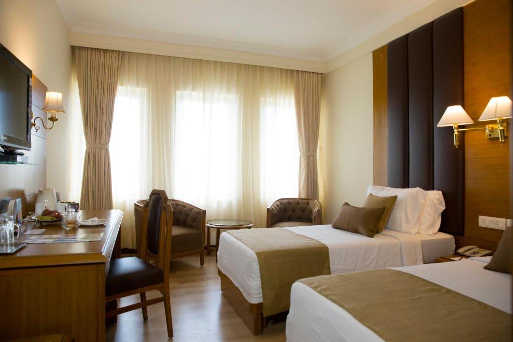 Postel nebo postele na pokoji v ubytování Peerless Hotel Kolkata