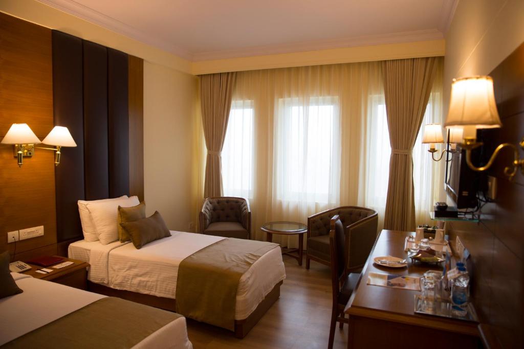 Postel nebo postele na pokoji v ubytování Peerless Hotel Kolkata