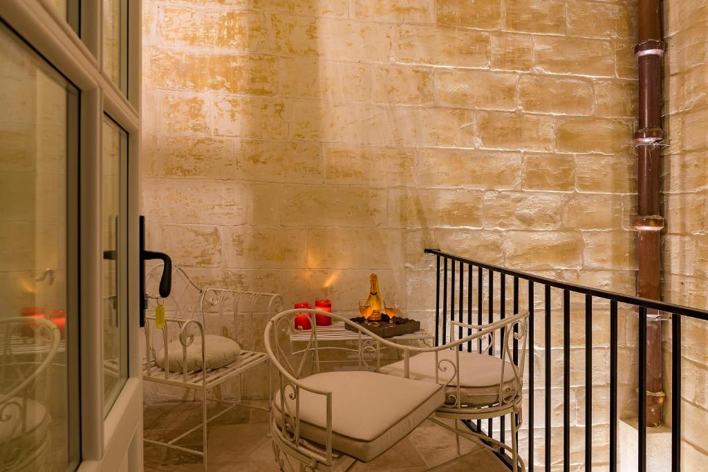 a room with a table and chairs on a balcony at The Snop House in Senglea