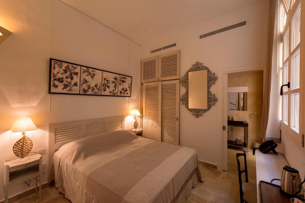 a bedroom with a bed and two lamps and a window at The Snop House in Senglea
