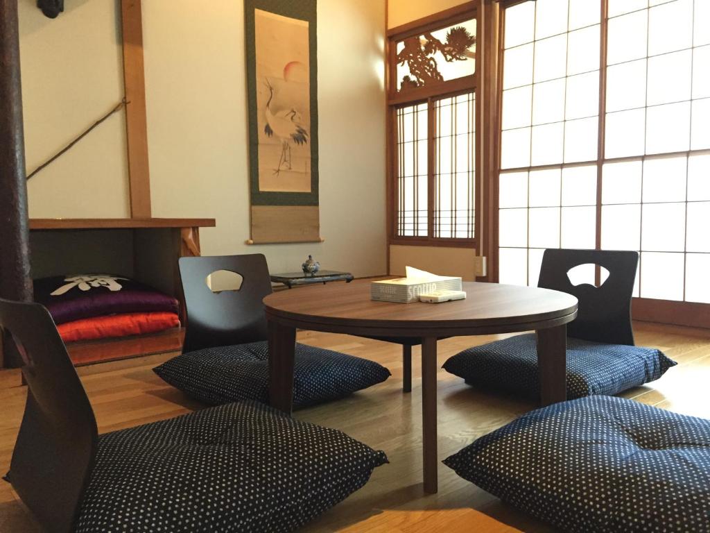 um quarto com uma mesa e cadeiras de madeira e uma mesa e cadeiras em 宿家STARY越中 izumicho em Toyama