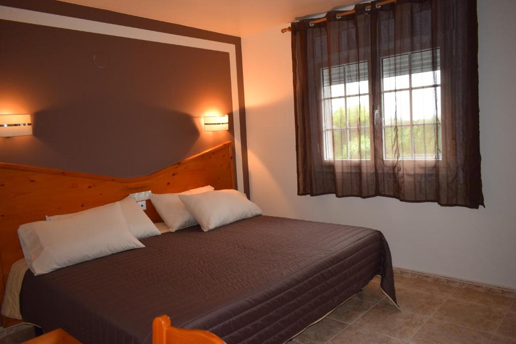 1 dormitorio con cama y ventana en Hotel Restaurante Las Camelias, en Jarrio