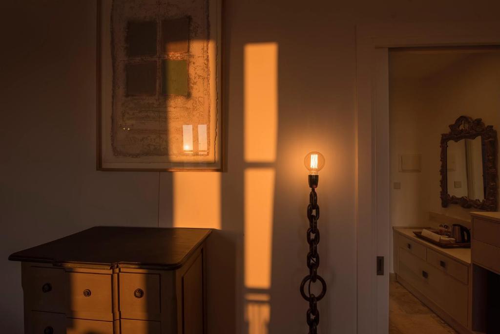 a light in a room with a dresser and a lamp at The Snop House in Senglea