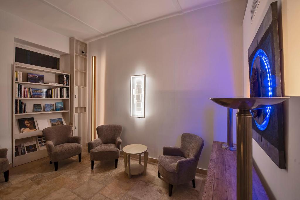 a living room with chairs and a table in a room at The Snop House in Senglea