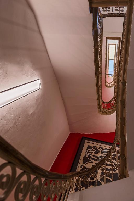 a spiral staircase with a red floor and a window at The Snop House in Senglea
